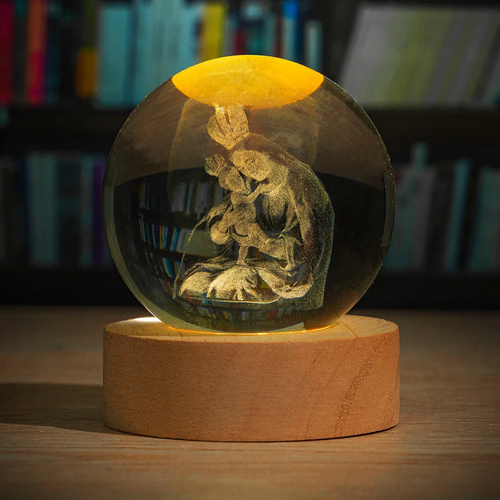 Esfera de cristal 3D con imagen sagrada grabada con láser y luz LED cálida sobre base de madera